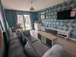 a living room with a couch and a tv at The Sty in Swindon
