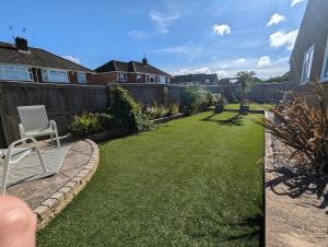 a backyard with a lawn with a chair and a fence at The Sty in Swindon