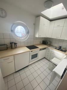 a white kitchen with a sink and a window at Sophies Apartment in Stuttgart
