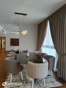 a dining room with chairs and a table and a room with a window at luxury apartment three bedrooms three bathrooms in 6th Of October