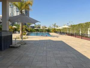 a swimming pool with an umbrella and chairs and a pool at luxury apartment three bedrooms three bathrooms in 6th Of October