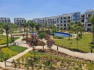 a park in front of a large apartment building at luxury apartment three bedrooms three bathrooms in 6th Of October