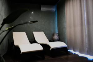 two white chairs in a room with a vase at Villa "Pied-à-terre" Residence & Spa in Umag