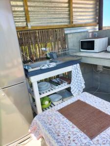 a kitchen with a sink and a shelf with dishes at Townsend Backpackers in Lambertʼs Bay