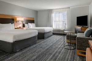 una habitación de hotel con dos camas y un sofá en TownePlace Suites by Marriott Ontario Airport, en Rancho Cucamonga