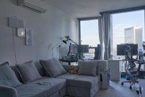 a living room with a couch and a large window at Shared Apartment Cozy Queen Room with Balcony in Melbourne
