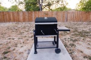 una parrilla sentada en un patio junto a una valla en Beautiful Family Home Mins to Lackland, en San Antonio