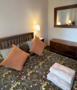 a bedroom with a bed with two towels on it at Wheel Corner Cottage in Kingsteignton