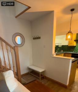 a living room with a couch and a kitchen at Wheel Corner Cottage in Kingsteignton