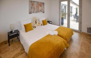 a large bed with a teddy bear sitting on top of it at 3 Bedroom Cozy Home In Mormoiron in Mormoiron