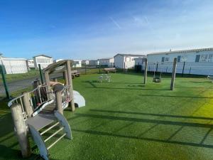 a park with a playground with benches on the grass at Dans le vent in Middelkerke
