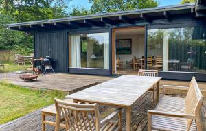 a patio with a wooden table and chairs on a deck at 4 Bedroom Beautiful Home In Vejby in Vejby