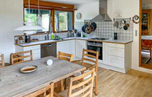 a kitchen with a wooden table and chairs in a room at 4 Bedroom Beautiful Home In Vejby in Vejby +2 photos