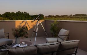 a balcony with a table and chairs and a telescope at Stunning Home In Kastelir With Sauna in Kaštelir +36 photos