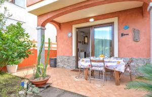 1 Bedroom Lovely Home In Viddalba في Viddalba: فناء مع طاولة وكراسي في منزل +12 صورة