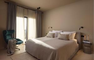 a bedroom with a large bed and a blue chair at Stunning Home In Kastelir With Sauna in Kaštelir