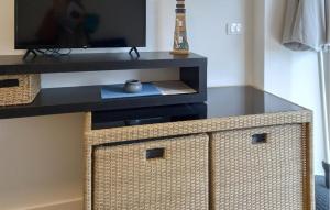a wicker cabinet with a television on top of it at 1 Bedroom Awesome Apartment In Vir in Vir
