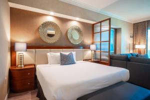 a bedroom with a large white bed and a couch at No Resort Fee Strip View Balcony+ Free Valet+Pool in Las Vegas +28 photos