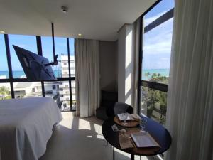 a hotel room with a bed and a large window at Condomínio Ozean - Bessa in Tambaú +276 photos