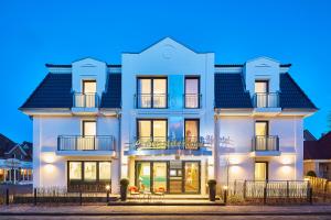 un edificio blanco con techo negro en Bernstein Hotel "50`s Seaside Motel", en Büsum