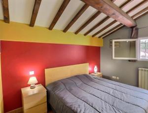 une chambre avec un lit et un mur rouge dans l'établissement EL ROCIO 1 GITES EQUESTRE, à Saintes-Maries-de-la-Mer 12 autres photos