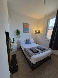 a bedroom with a bed and a window at Grand Vintage Home with Sauna & Style in Kirby Muxloe +18 photos