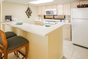 Una cocina con encimera y refrigerador blanco. en Royale Beach and Tennis Club, en South Padre Island