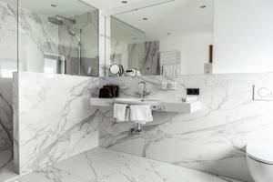 a white bathroom with a sink and a mirror at Hotel Maria Theresia in Mayrhofen