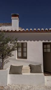a couch sitting outside of a house with a window at Casa da Oliveira - Bordeira in Bordeira +27 photos