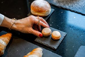 a woman is reaching for two pastries on a table at Hotel Maria Theresia in Mayrhofen +56 photos