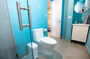 a bathroom with a toilet and a blue wall at Aquabella 4 Island Serenity in Isla Verde in San Juan