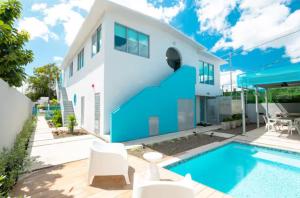 a villa with a swimming pool and a house at Aquabella 4 Island Serenity in Isla Verde in San Juan