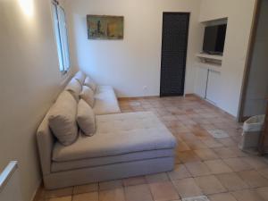 a living room with a couch and a television at Rez de villa avec piscine in Menton