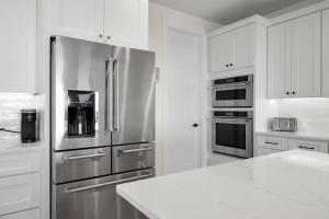 a kitchen with stainless steel appliances and white cabinets at Beachside Beauty at Surfview Paradise in Palm Coast