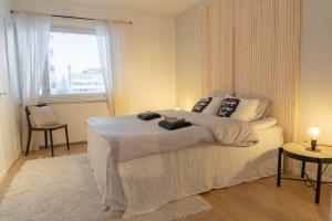 a bedroom with a large bed and a window at Arctic City Apartment in Rovaniemi