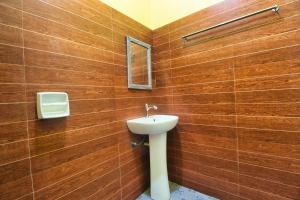 a bathroom with a sink and a mirror at Casa Luntian Lodge and Cafe in Puerto Galera
