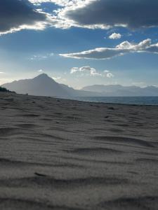 una playa de arena con vistas al océano y a las montañas en Alba Gold LUXURY SUITE & VILLA, en Cefalú