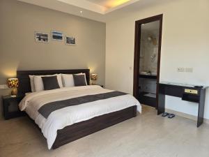 a bedroom with a large bed and a mirror at Two Green Park in New Delhi