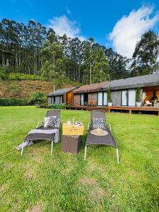 dos sillas sentadas en el césped frente a una casa en Casa na Montanha em Sapucaí Mirim-MG, en Santa Luísa de Baixo