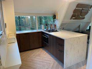 a kitchen with a counter with a stove and a window at Vakantiewoning Sunclass Durbuy Ardennen huisnummer 68 in Durbuy