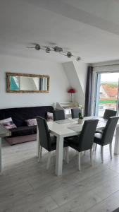 a dining room with a white table and chairs at Sea view - Vue mer - Proche commerces - Nausicaa in Wimereux