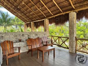 two chairs and a table on a porch at Suite Ixchel Rancho Sodzil in Tizimín