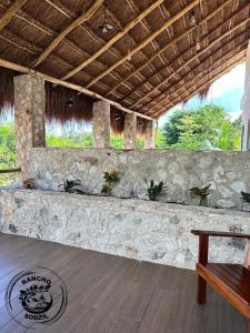 a room with a bench and a stone wall at Suite Ixchel Rancho Sodzil in Tizimín