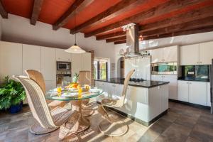 a kitchen with a glass table and chairs at Gorgeous Spanish Chalet, Pool and Views in Málaga +31 photos