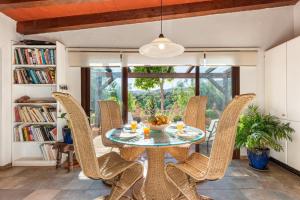 a dining room with a glass table and wicker chairs at Gorgeous Spanish Chalet, Pool and Views in Málaga