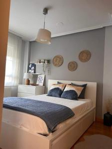 a bedroom with a large bed with blue pillows at La Fontana in Santa Marta de Tormes