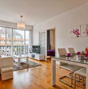 a living room with a table and chairs and a couch at Urban Lodge YourHostHelper in Deauville