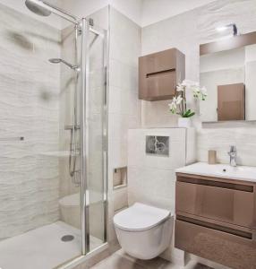 a bathroom with a shower and a toilet and a sink at Urban Lodge YourHostHelper in Deauville