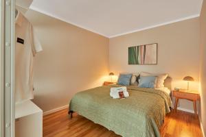 a bedroom with a bed with a green blanket at Nicole, schönes Apartment mit Sauna in Pforzheim