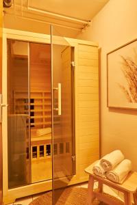 a glass shower in a bathroom with a bench at Nicole, schönes Apartment mit Sauna in Pforzheim